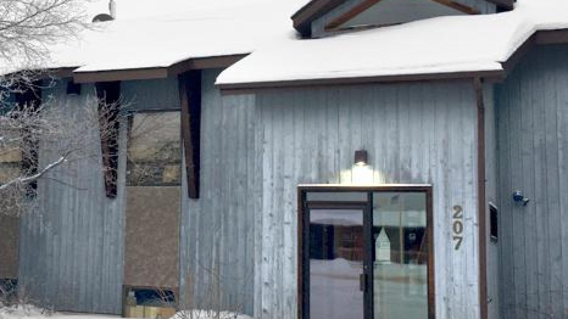 Exterior of wooden building covered with snow.