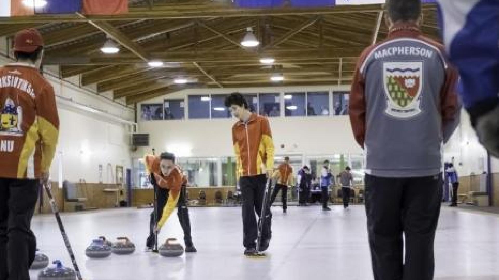 Curling teams playing curling at arena.