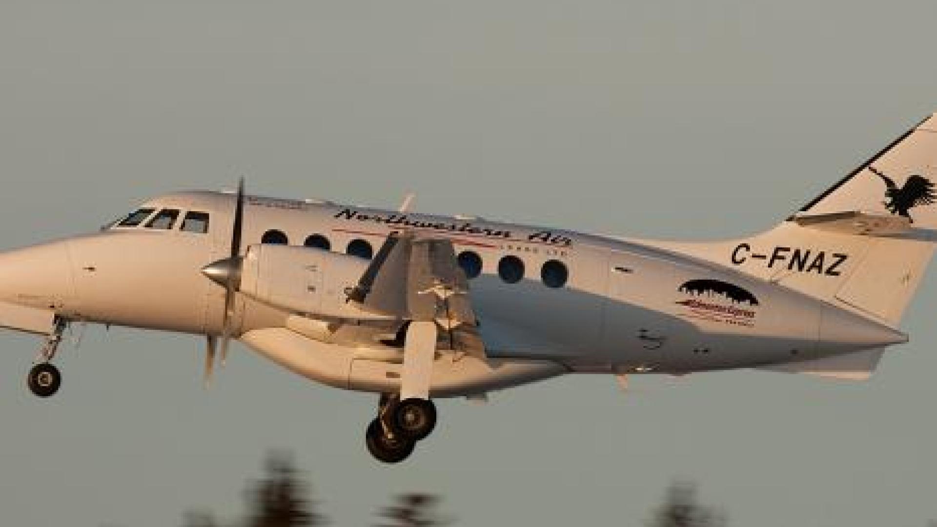 Side of propeller airplane in mid flight.